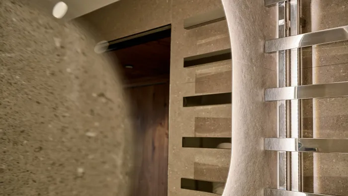Bagno moderno con pareti in pietra testurizzata e scaldasalviette cromato